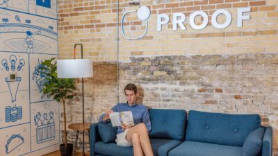 man sitting on blue sofa while reading book
